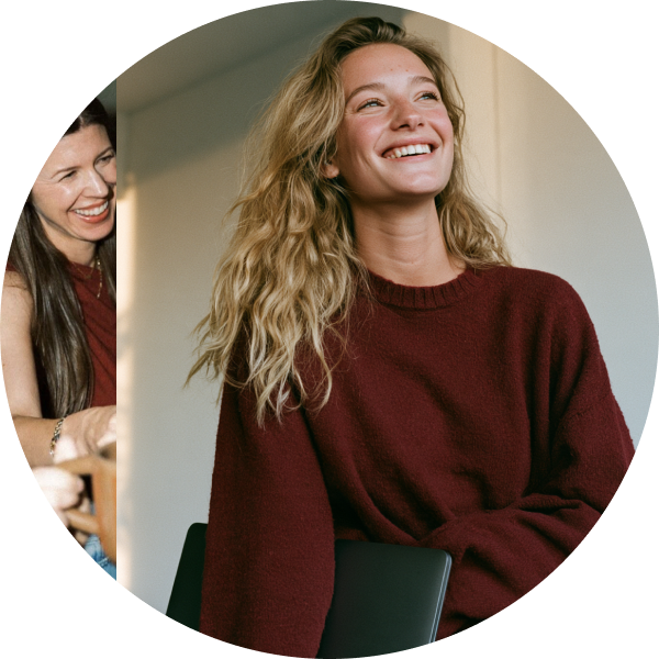 A woman in a red jumper laughing with a colleague