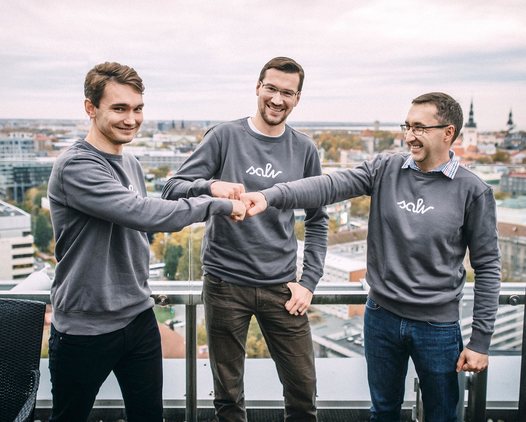 Three of the Salv team bumping fists on a rooftop terrace
